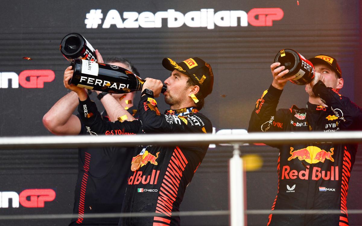 Max Verstappen a Sergio Pérez so šampanským na pódiu VC Azerbajdžanu 2023
