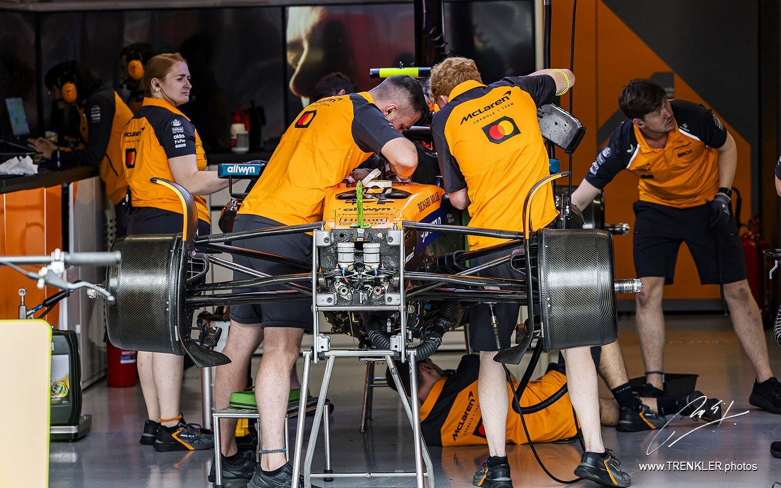 Monopost McLarenu v garáži, mechanici