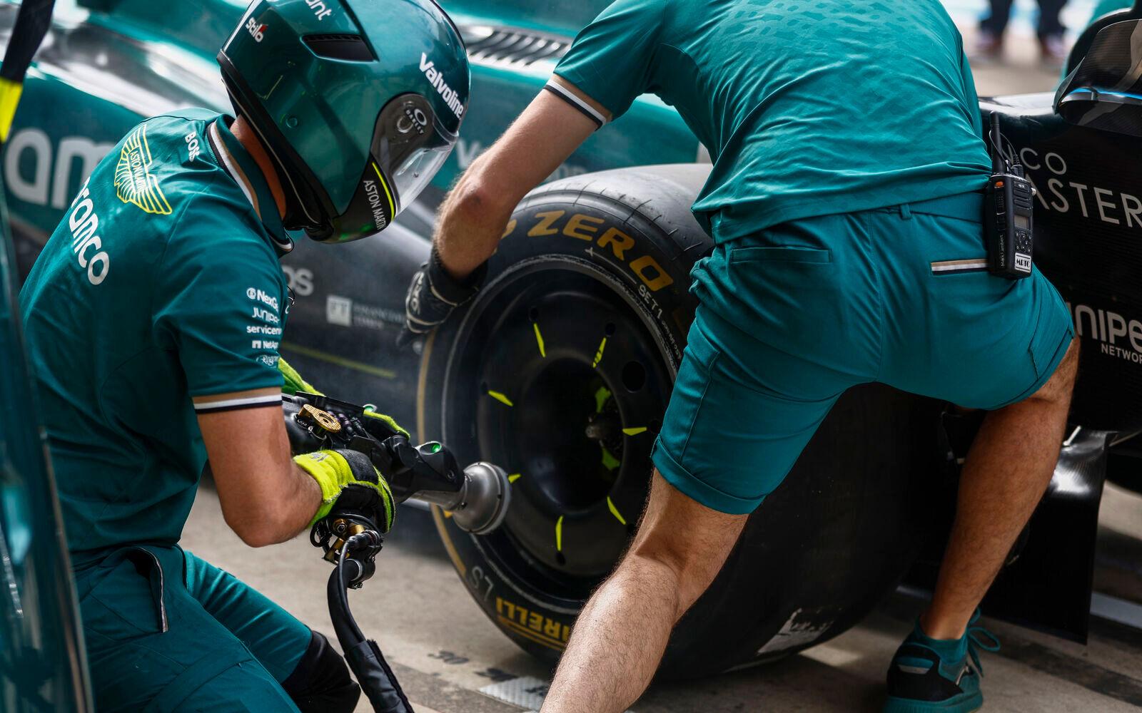 Mechanik Aston Martinu mení pneumatiku Pirelli