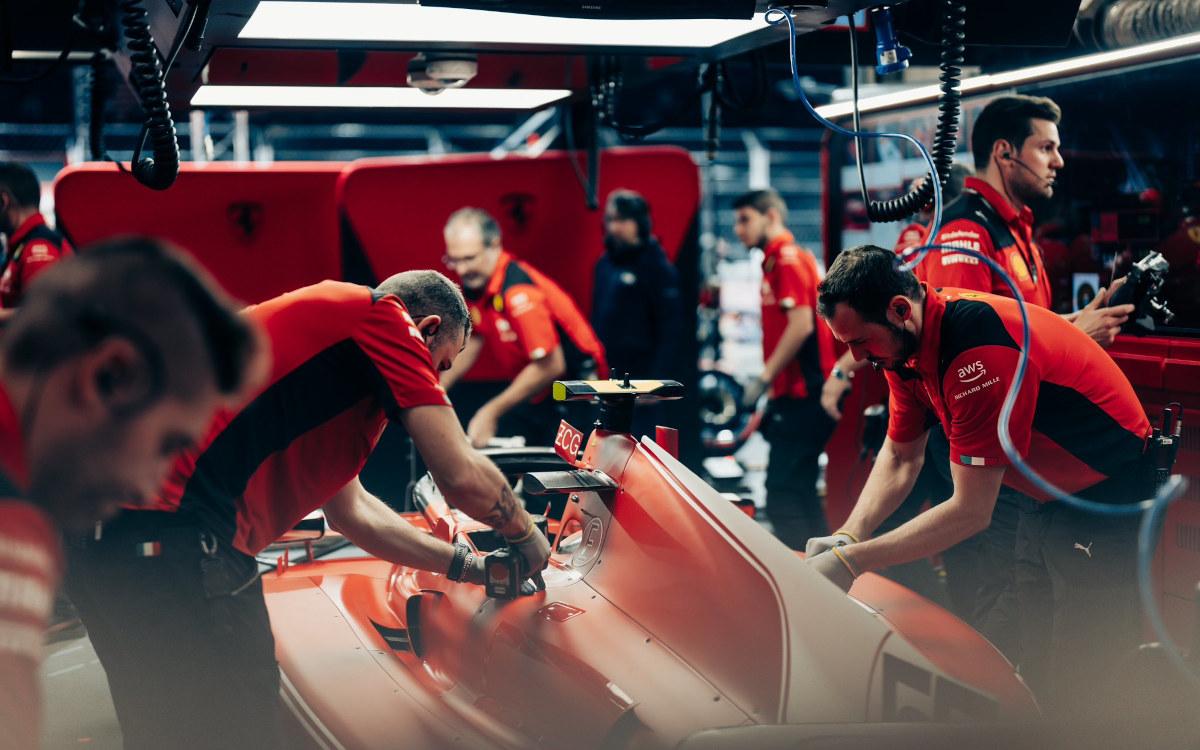 Mechanici Ferrari pracujú na aute Carlosa Sainza
