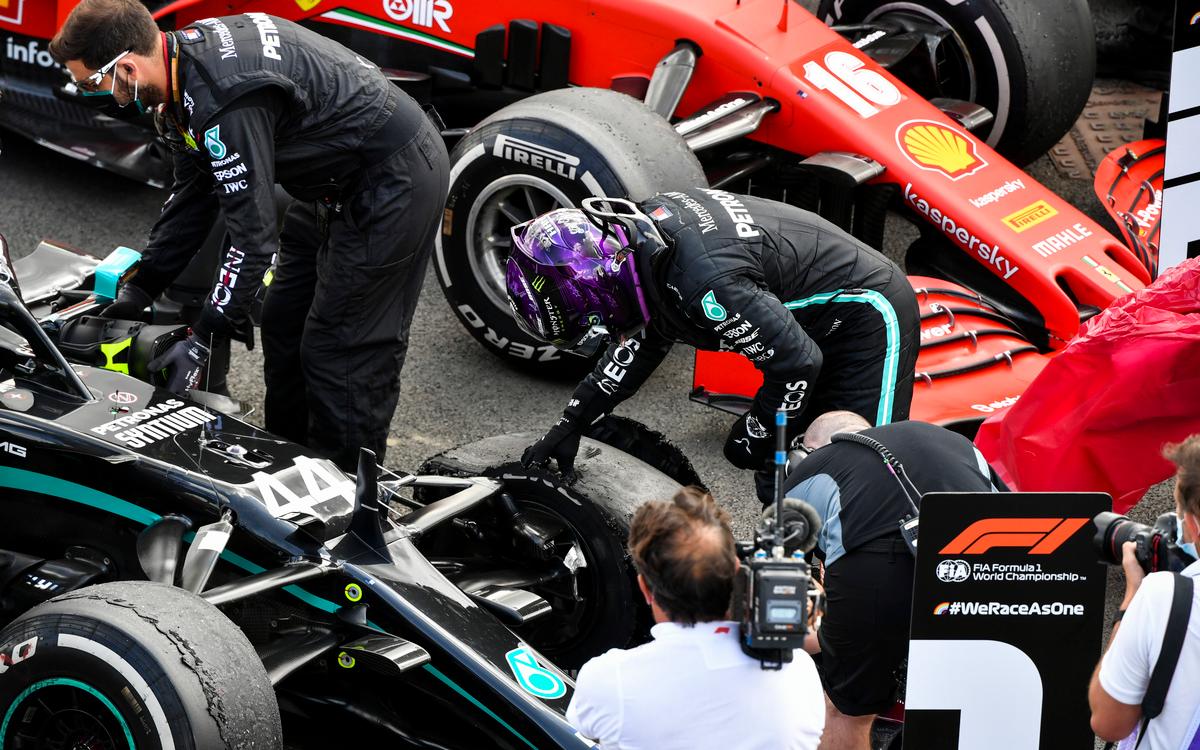 Lewis Hamilton skúma zničenú pneumatiku